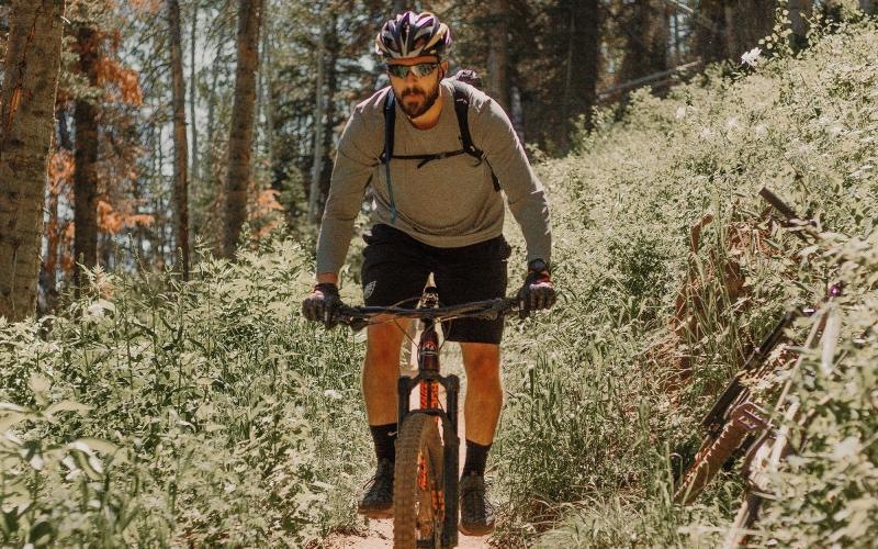 man riding a bike on a trail in the woods